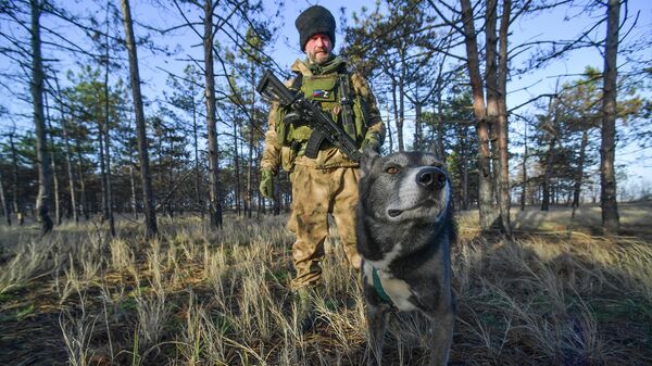 Военнослужащий казачьего батальона Терек и его собака на боевой позиции