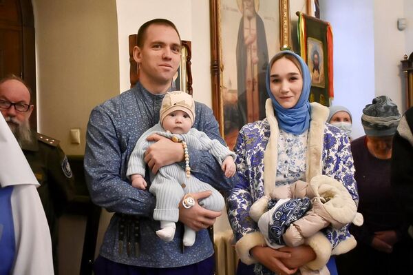 Андрей Ростовщиков с женой и сыном в церкви 