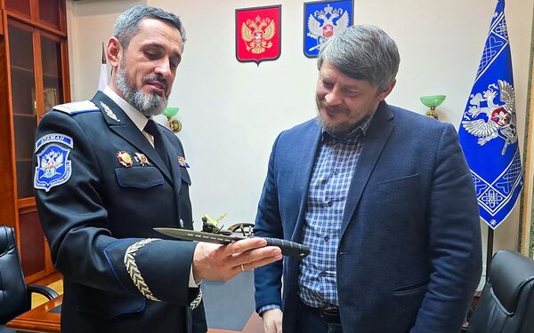 Виталий Кузнецов вручает Николаю Дьяконову боевой нож с дарственной надписью