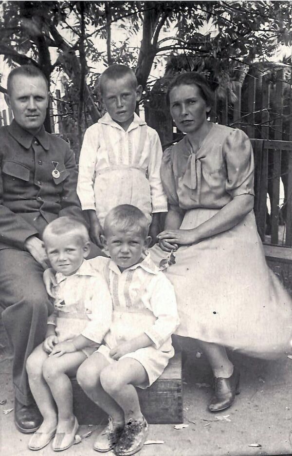 Наталья Ивановна и Василий Иванович с детьми: между ними Борис, сидят Леонид и Евгений. 1944 год