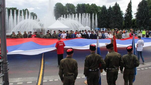 Активисты Волонтерской Роты разворачивают флаг России