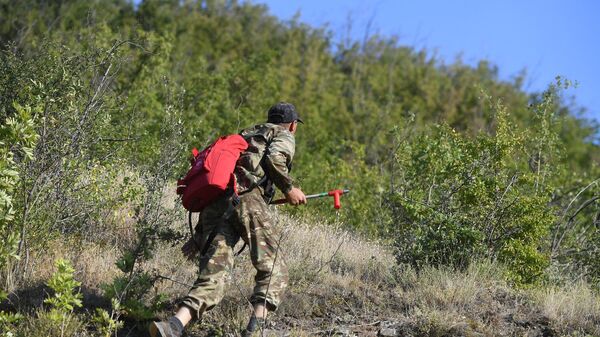 Спасатель с водным ранцем выдвигается к месту лесного пожара