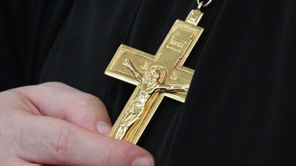 Священнослужитель держит православный крест