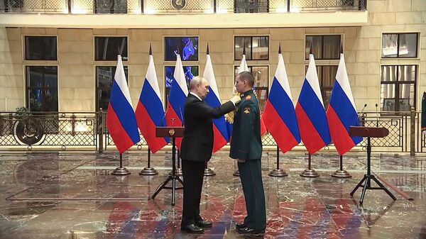 Президент РФ Владимир Путин вручает медаль Золотая звезда реестровому казаку Юрию Петрову 