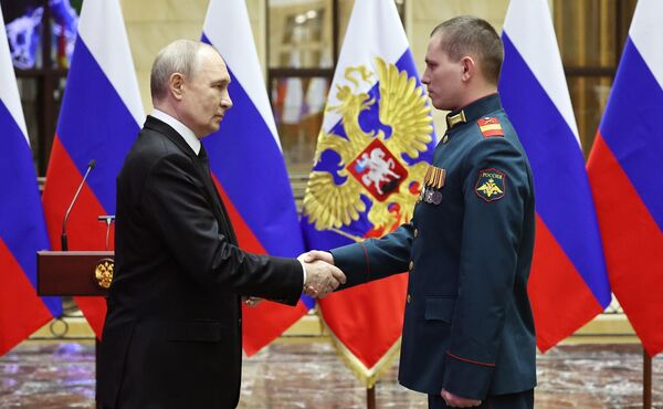 Президент РФ Владимир Путин вручает медаль Золотая звезда реестровому казаку Юрию Петрову 