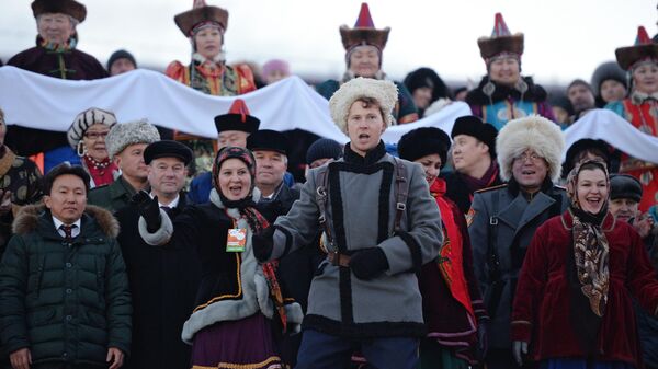 Люди в народных костюмах на встрече Олимпийского огня в городе Улан-Удэ в Бурятии