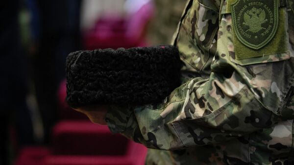 Казак держит в руках кубанку 