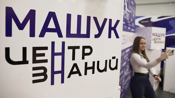 Девушка фотографируется у стенда в Центре знаний Машук